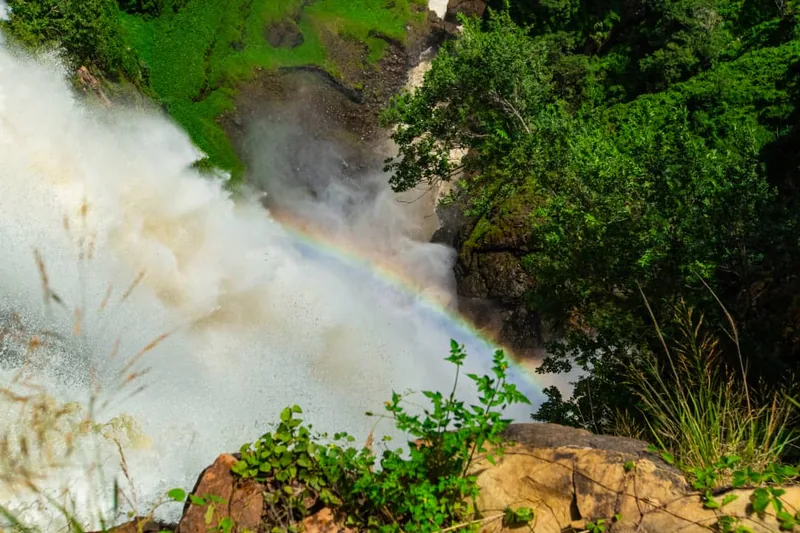 A rainbow arcing through the spray at the base of Kalambo Falls