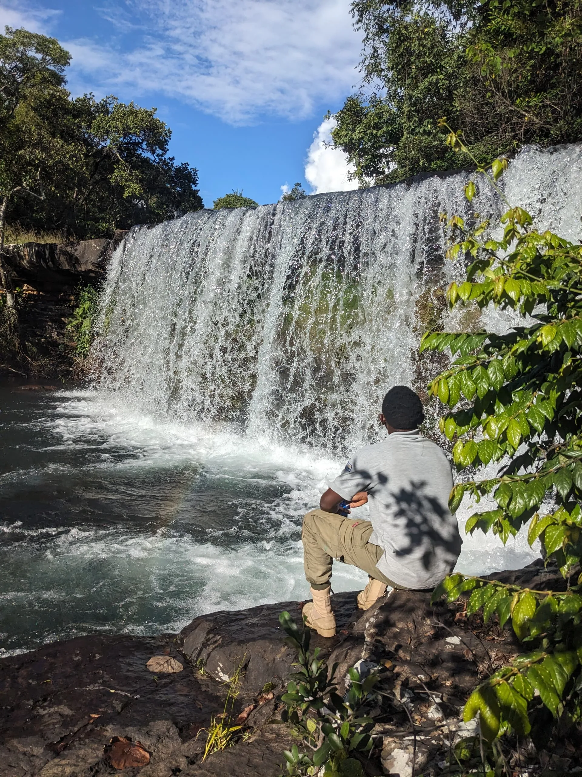 A ranger pausing to view a waterfall at Mpanga-Kipengere Game Reserve